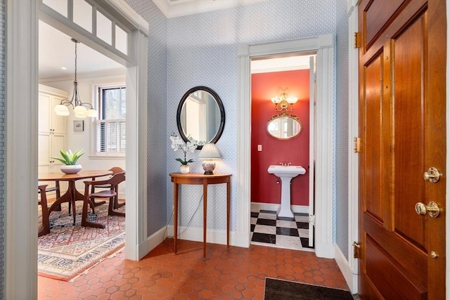 foyer featuring wallpapered walls, dark floors, and baseboards