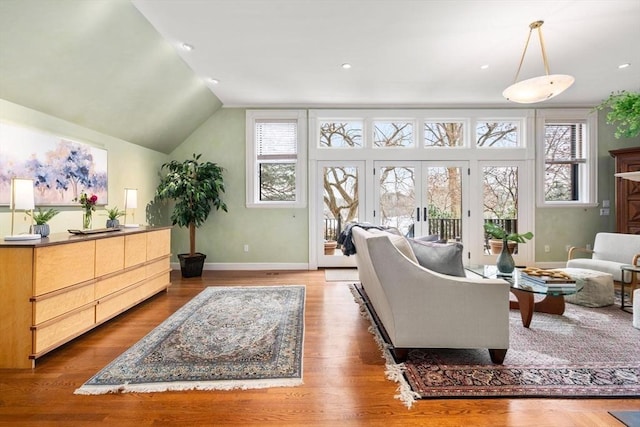 living room with baseboards, lofted ceiling, wood finished floors, french doors, and recessed lighting