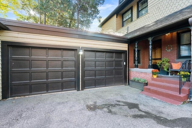 garage with driveway and a porch