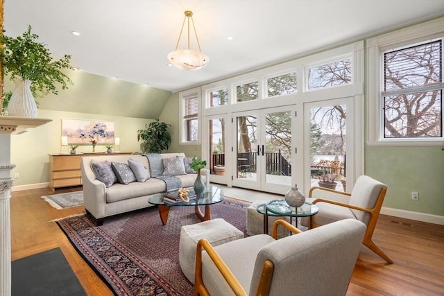 living area featuring french doors, plenty of natural light, wood finished floors, and baseboards