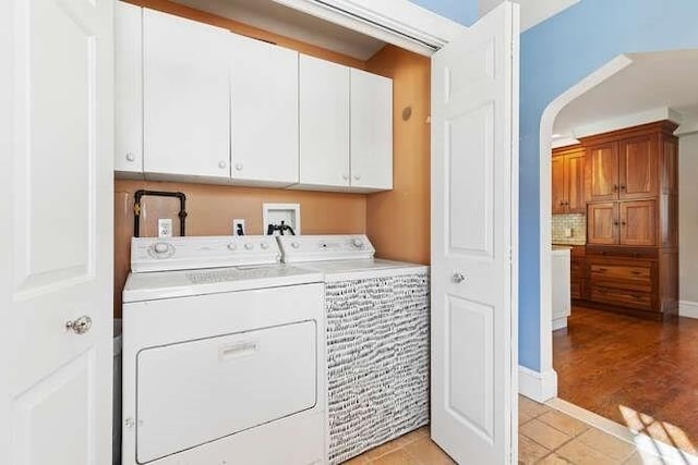 laundry area with cabinets, independent washer and dryer, and light tile patterned flooring