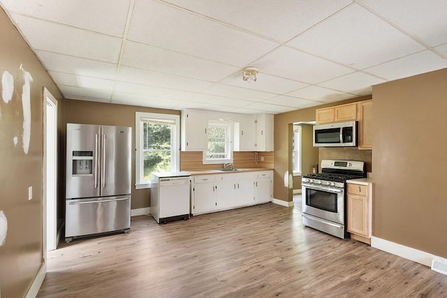 436 Maple St, Winchendon, MA 01475 - kitchen with appliances with stainless steel finishes, a drop ceiling, light countertops, light wood-type flooring, and white cabinetry