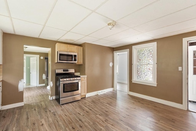 436 Maple St, Winchendon, MA 01475 - kitchen with stainless steel appliances, light brown cabinetry, light wood-style flooring, a paneled ceiling, and light countertops