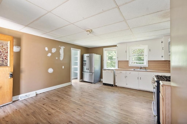 436 Maple St, Winchendon, MA 01475 - kitchen with appliances with stainless steel finishes, a paneled ceiling, white cabinetry, light wood-type flooring, and light countertops