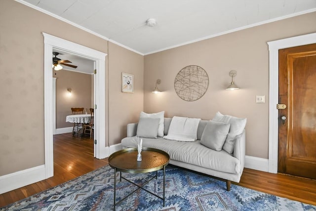 living room featuring ornamental molding, baseboards, and wood finished floors