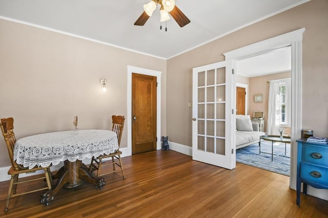 dining space featuring french doors, wood-type flooring, baseboards, ceiling fan, and ornamental molding