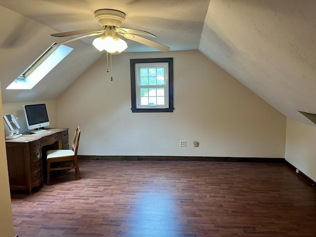 unfurnished office featuring wood finished floors, a skylight, a ceiling fan, vaulted ceiling, and baseboards