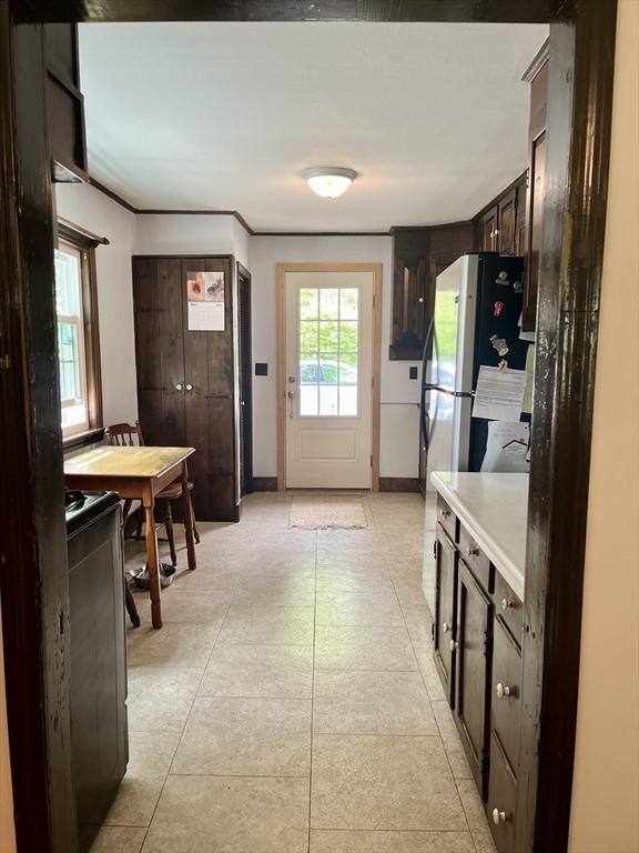 kitchen with dark brown cabinetry, light countertops, and baseboards