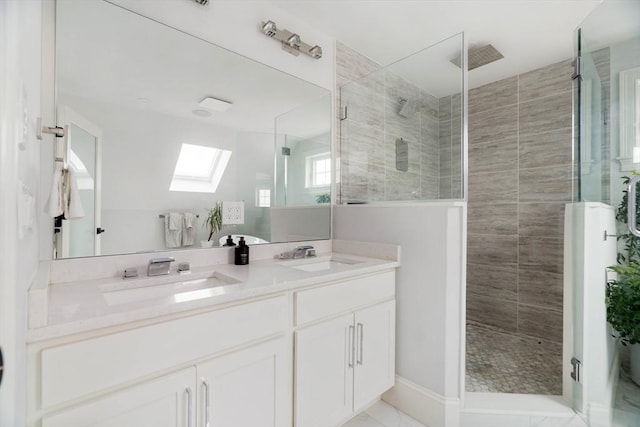 bathroom featuring walk in shower, vanity, and a skylight