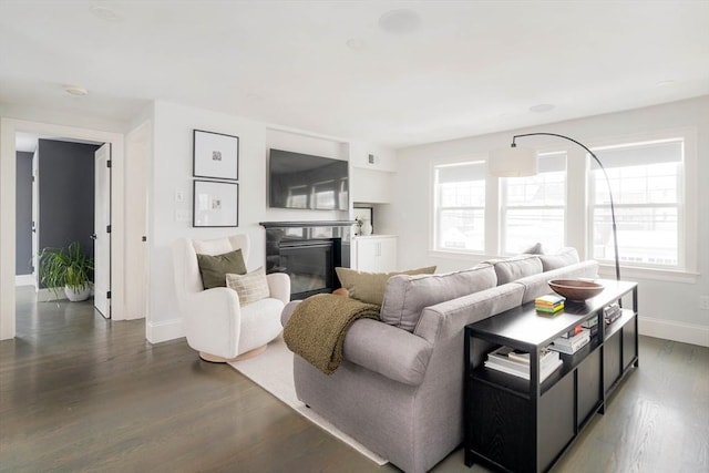 living room with dark wood-type flooring and plenty of natural light