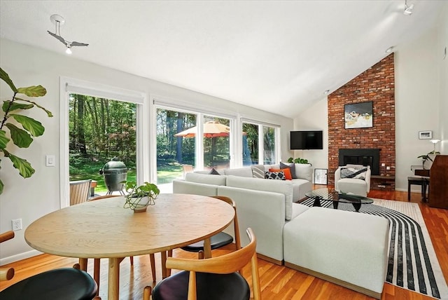 13 Robinwood Rd, Acton, MA 01720 - living area with healthy amount of natural light, a brick fireplace, light wood finished floors, and vaulted ceiling