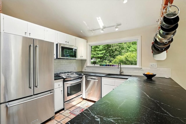 13 Robinwood Rd, Acton, MA 01720 - kitchen featuring stainless steel appliances, a sink, dark countertops, decorative backsplash, and white cabinetry