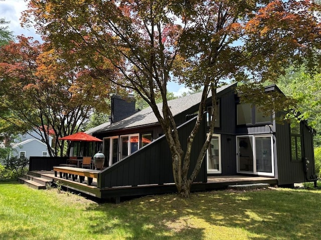 13 Robinwood Rd, Acton, MA 01720 - rear view of house featuring a yard, a deck, board and batten siding, and a chimney