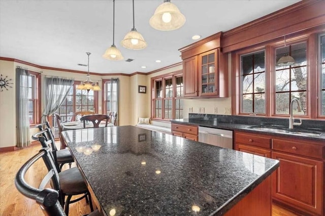 kitchen with dishwasher, a center island, a breakfast bar, sink, and hanging light fixtures