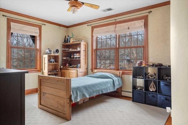 carpeted bedroom with ceiling fan, crown molding, and baseboard heating