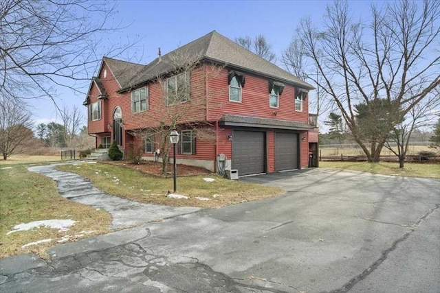 view of side of property featuring a garage and a yard