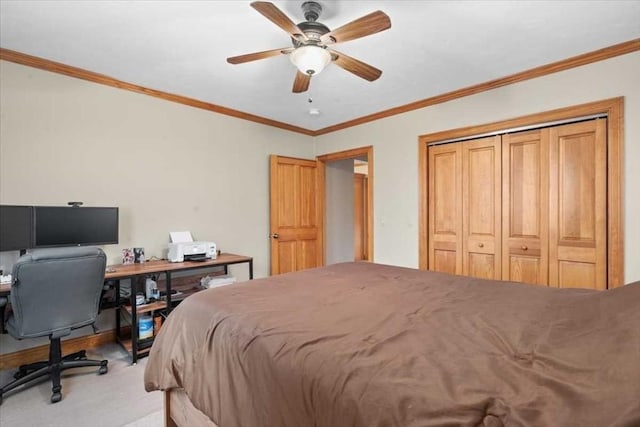 bedroom featuring ceiling fan, crown molding, light colored carpet, and a closet