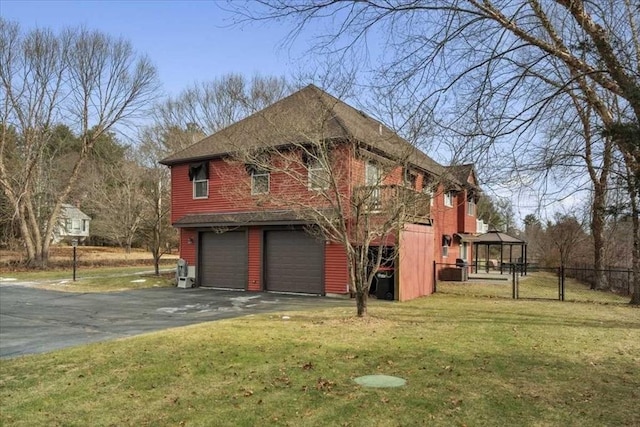 view of property exterior with a garage, a gazebo, and a yard