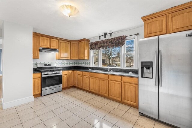 kitchen with decorative backsplash, light tile patterned flooring, sink, and appliances with stainless steel finishes