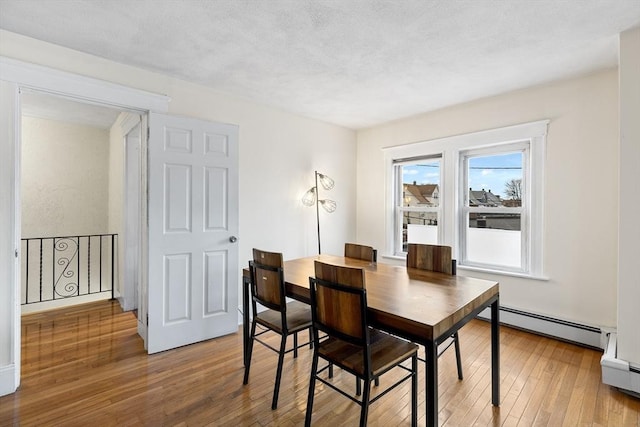 dining room featuring hardwood / wood-style floors and baseboard heating