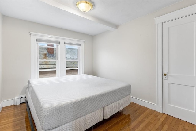 bedroom with wood-type flooring and baseboard heating