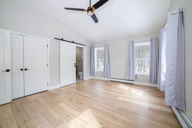 3 Woods Rd, Westminster, MA 01473 - unfurnished bedroom featuring light wood finished floors, a barn door, a baseboard radiator, and lofted ceiling