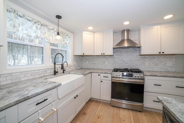 3 Woods Rd, Westminster, MA 01473 - kitchen with stainless steel gas stove, white cabinets, light wood-style floors, wall chimney range hood, and a sink
