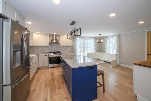 3 Woods Rd, Westminster, MA 01473 - kitchen with a kitchen bar, decorative backsplash, appliances with stainless steel finishes, white cabinetry, and wall chimney exhaust hood