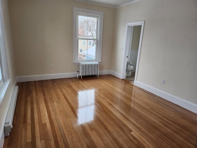 empty room featuring light hardwood / wood-style flooring, a baseboard heating unit, and radiator heating unit