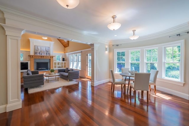 dining space with dark wood-type flooring, ornamental molding, a healthy amount of sunlight, and ornate columns