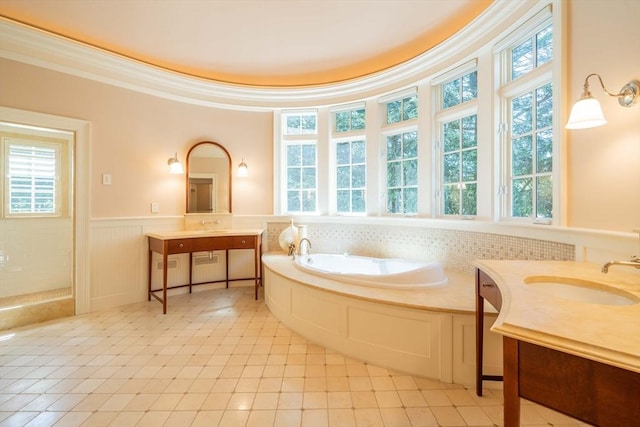 bathroom featuring ornamental molding, a washtub, and vanity