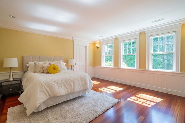 bedroom with crown molding and dark hardwood / wood-style floors