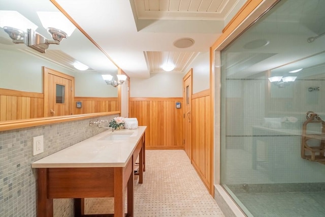 bathroom with a shower with door, vanity, ornamental molding, and wooden walls