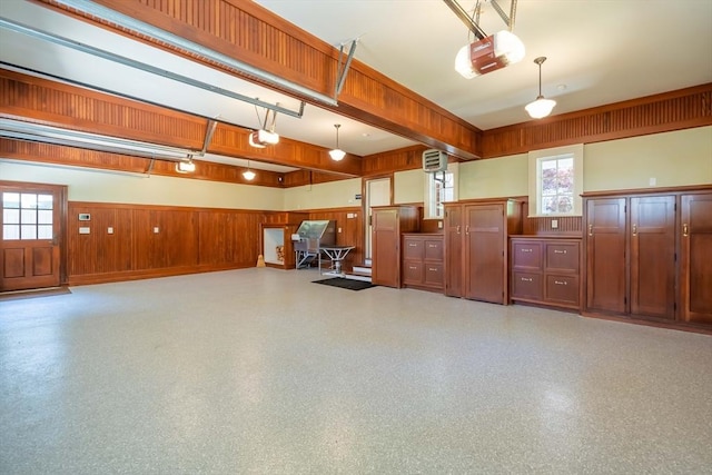 garage featuring a garage door opener and wood walls