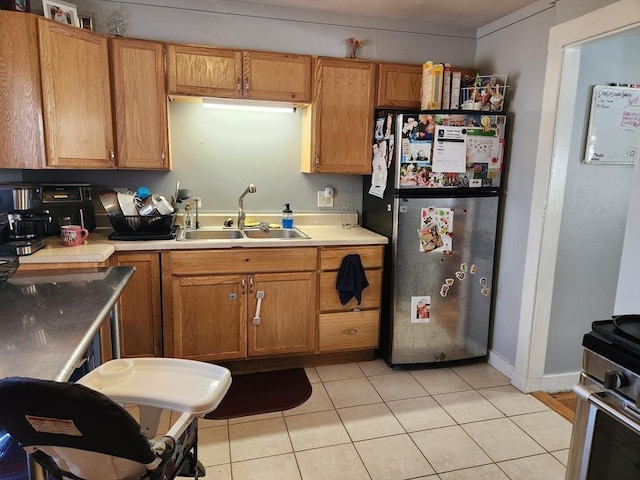 889 Amesbury Rd, Haverhill, MA 01830 - kitchen featuring freestanding refrigerator, light tile patterned flooring, light countertops, range, and brown cabinetry