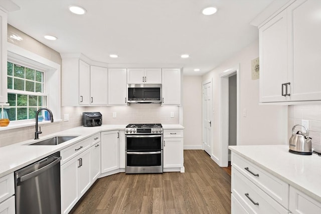 10 Carlisle Rd Unit 10, Bedford, MA 01730 - kitchen with appliances with stainless steel finishes, wood finished floors, decorative backsplash, light countertops, and recessed lighting