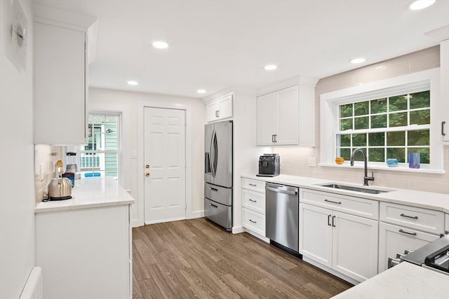 10 Carlisle Rd Unit 10, Bedford, MA 01730 - kitchen featuring appliances with stainless steel finishes, white cabinets, decorative backsplash, dark wood finished floors, and recessed lighting