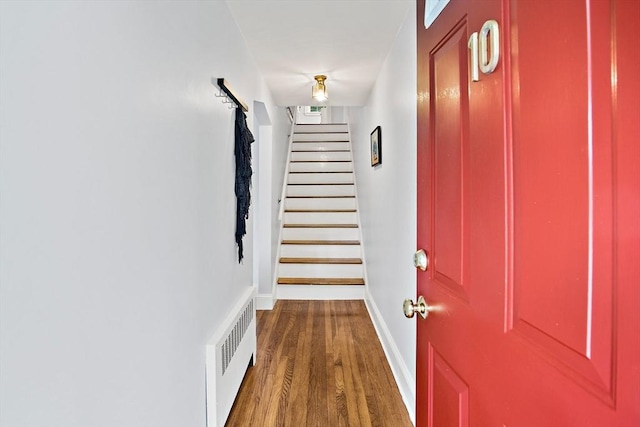 10 Carlisle Rd Unit 10, Bedford, MA 01730 - hallway featuring radiator, wood finished floors, and stairway