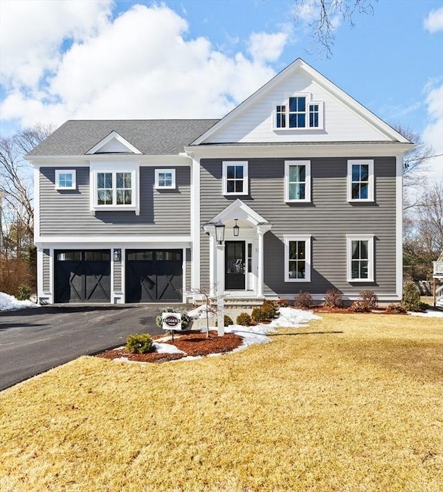 view of front of property featuring a front lawn, driveway, and an attached garage