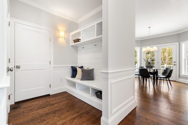 mudroom with dark wood-style floors, a notable chandelier, crown molding, and a decorative wall