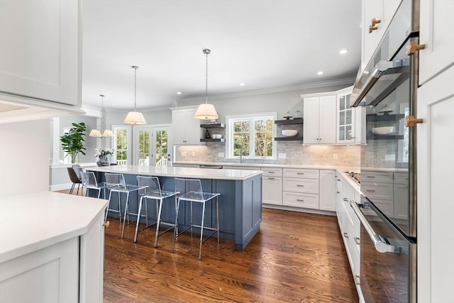 kitchen with dark wood-style floors, a kitchen bar, white cabinetry, open shelves, and backsplash