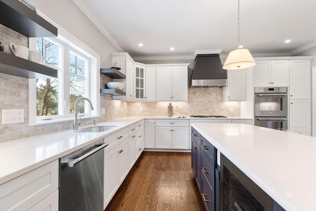 kitchen with a sink, white cabinetry, wall chimney range hood, appliances with stainless steel finishes, and open shelves