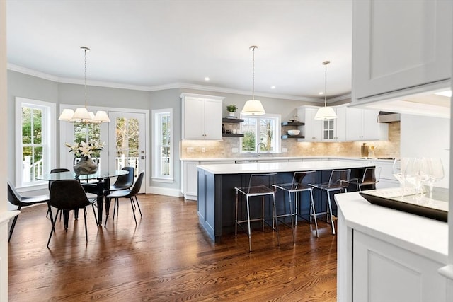 kitchen with dark wood-style floors, open shelves, light countertops, white cabinets, and a kitchen island