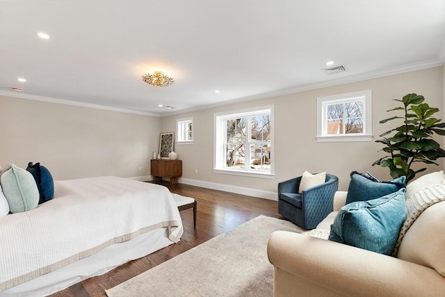 bedroom featuring ornamental molding, wood finished floors, visible vents, and baseboards