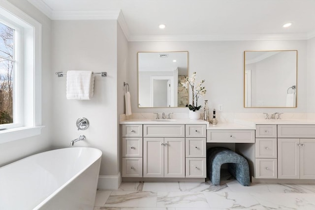 full bathroom with ornamental molding, recessed lighting, a freestanding tub, and vanity