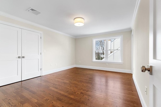 interior space with baseboards, visible vents, wood finished floors, crown molding, and a closet