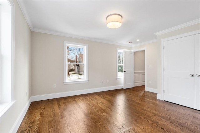 unfurnished bedroom with ornamental molding, baseboards, and wood finished floors