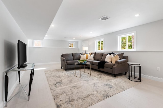 living room with baseboards, visible vents, and recessed lighting