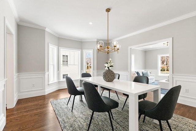 dining room with a wainscoted wall, a chandelier, dark wood-type flooring, and ornamental molding