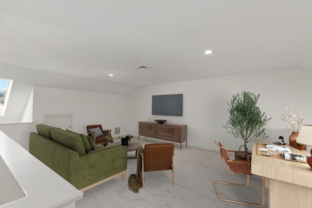 living room featuring lofted ceiling with skylight, light colored carpet, and visible vents